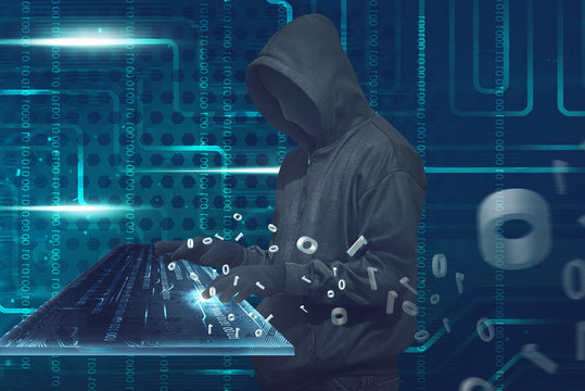 Hooded man with anonymous mask typing on virtual keyboard