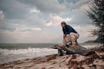 handsome guy in casual wear on the beach at stormy weather