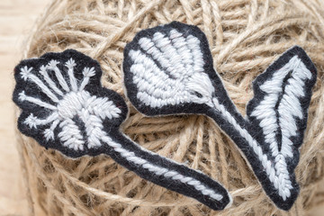 Two home-made embroidered black and white flowers on the background of the thread ball