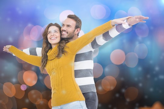 Composite image of young couple standing with arms outstretched