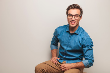 casual man sitting and smiling in studio with copy space