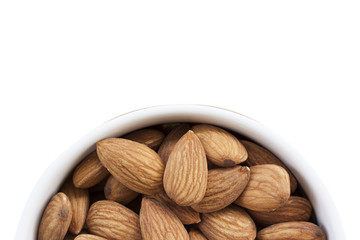Almonds isolated on a white background, or on a plain wooden table.