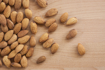 Almonds isolated on a white background, or on a plain wooden table.