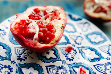 Garnet on plate with blue and white pattern on wooden background