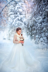 Fototapeta na wymiar Beautiful bride in snowy winter forest