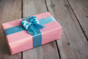 Handmade pink gift box with blue ribbon and bow.
