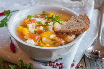 Vegetable soup with bread on wooden table