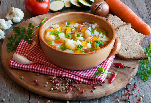 Vegetable soup with bread on wooden table