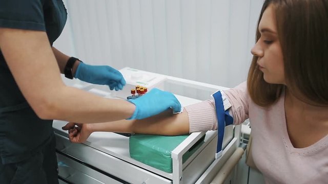 The doctor takes blood from a vein from the woman