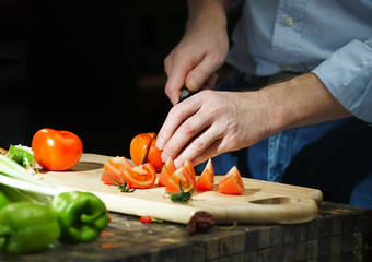 Chef cuts the tomatoes with a knife