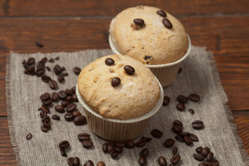 Obraz na płótnie Canvas Tasty muffin cakes on burlap, spices and coffee beans