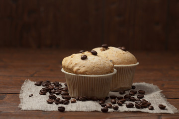 Tasty muffin cakes on burlap, spices and coffee beans