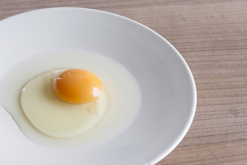 Eggs cooking for breakfast, a protein form yolk and albumen on a white background, or on a plain wooden table.