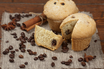 Tasty muffin cakes on burlap, spices and coffee beans