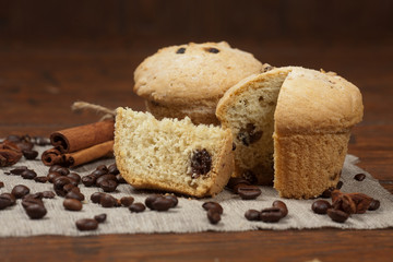 Tasty muffin cakes on burlap, spices and coffee beans