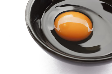 Eggs cooking for breakfast, a protein form yolk and albumen on a white background, or on a plain wooden table.