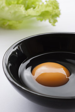 Eggs cooking for breakfast, a protein form yolk and albumen on a white background, or on a plain wooden table.