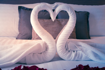 Couple swan made from white towels on the bed