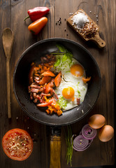 Home fried eggs in a pan. Scrambled  with cherry tomatoes, croutons and red paprika. Beautiful .