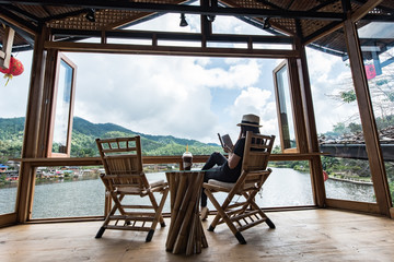 Woman reading a book lying and drink ice coffee on the chair,