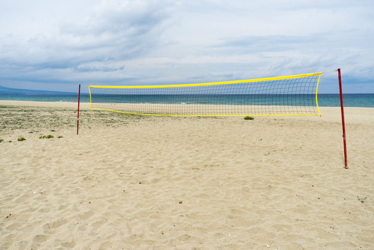 View on Mediterranean Sea sunny sand beach with volleyball net. Nei Pori village, Pieria, Greece.

