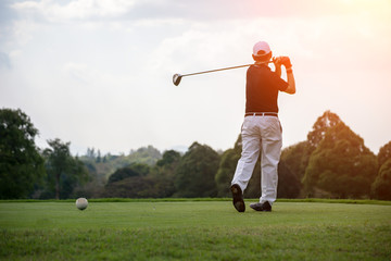 Golfers men player golf hit swing shot on course sunset.