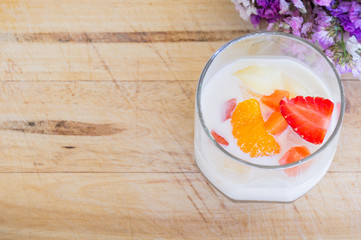 Milk Pudding with fruits in glass on wooden background. Milk Pudding decorate dessert bowl set on Wooden Table .