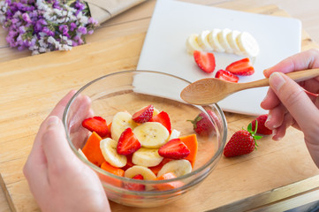 eating healthy. dieting. fruits kitchen and cooking at home. close up of healthy fruits salad bowl on wooden background at home.