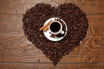 Heart from beans with a cup of coffee