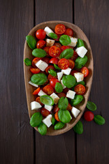 caprese salad on dark wooden surface