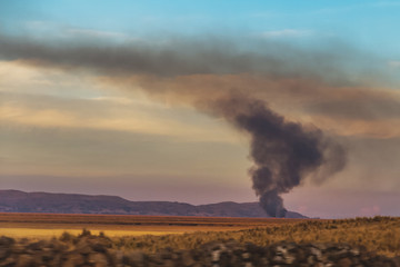 Obraz na płótnie Canvas Peru. Fire in the middle of the field, sunset.