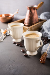 Two retro cups of coffee and old coffee pot on dark brown background with copy space.