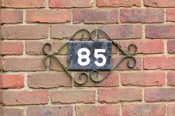 House number 85 sign on wall