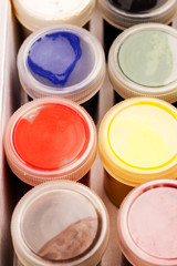Closed different color gouache jars folded in box, close-up shot