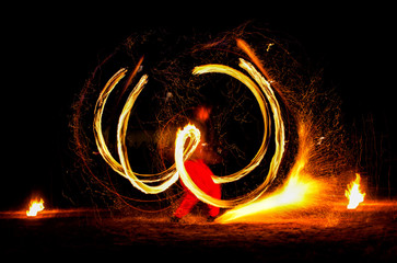 Man entertains the audience with the help of fire, carrying fire performance night.