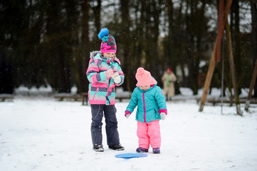 Two little girls on walk in winter day.