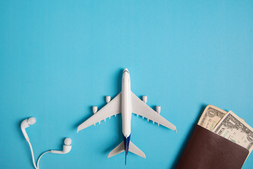Preparation for Traveling concept, airplane, money, passport, earphone, book, on blue background...