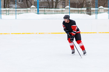 Professional Ice hockey player with stick skating on the rink. Image with copy space