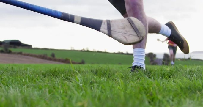 Hurling player strikes ball while being tackled