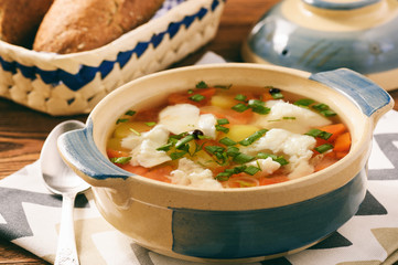 Clear fish soup with vegetables.