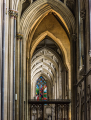 Inside Bristol Cathedral in Bristol, England showing dazzling stained glass windows and impressive architecture