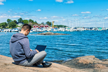 Fototapeta premium man with laptop on colorful beach of island