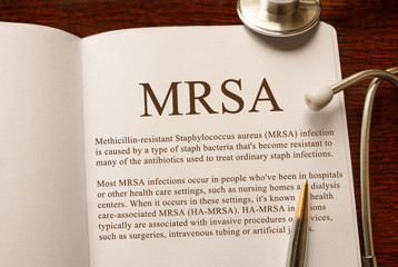 Page with MRSA Methicillin-resistant Staphylococcus aureus infection on the table with stethoscope, medical concept