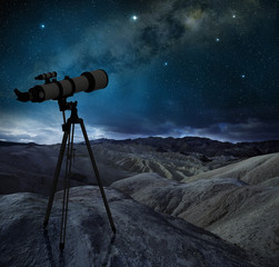 Obraz premium telescope tripod pointing the milky way in a desert landscape