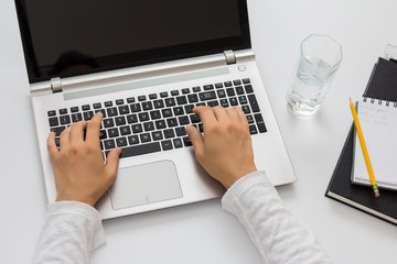 White desk, paperwork and silver laptop