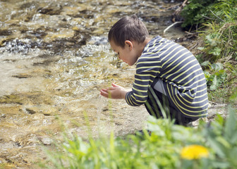 Child by playing in river water