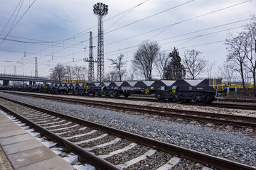 Fototapeta premium Burgas, Bulgaria - January 24, 2017 - Freight cargo train - black cars wagons - New 6-axled flat wagon - Type: Sahmmn - Model WW 604 A - Transvagon AD
