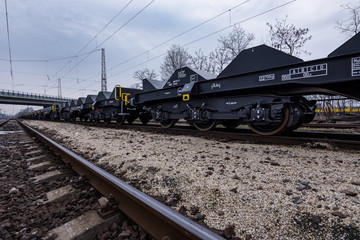 Fototapeta na wymiar Burgas, Bulgaria - January 24, 2017 - Freight cargo train - black cars wagons - New 6-axled flat wagon - Type: Sahmmn - Model WW 604 A - Transvagon AD