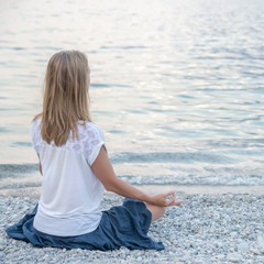 Fototapeta na wymiar Woman meditating at the lake