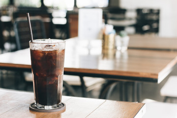 Cold black coffee on the table in the coffee shop with vintage 